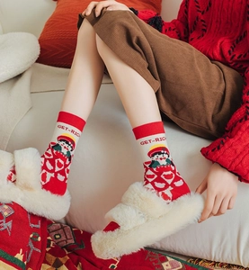 Detail of red festive cotton socks with GET-RICH embroidery and cartoon jacquard pattern