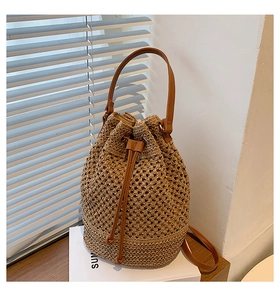 Detailed close-up of brown straw woven bucket bag with PU leather drawstring closure