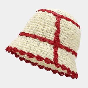 Detail of hand-woven straw bucket hat with red wavy trim and cross patterns