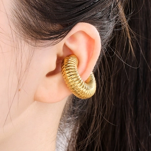 Macro shot of 18k gold plated hollow croissant ear cuff with ribbed geometric texture
