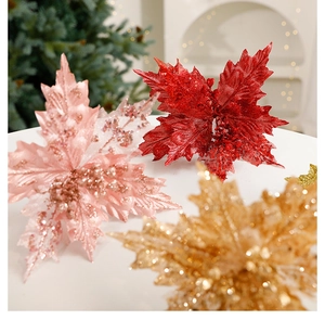 Macro shot of glittery artificial poinsettia leaves in red, pink, and gold for Xmas