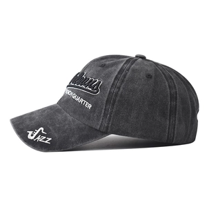 Detail of embroidered Pelicans text and Jazz saxophone on washed black cotton baseball cap