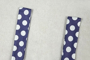 Detailed view of the navy blue straps with white polka dot patterns and fabric texture