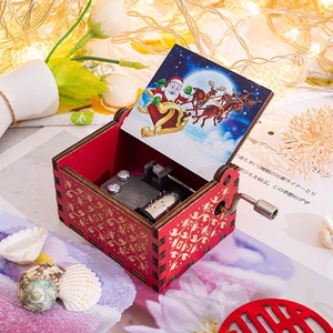 Detail view of red wooden music box with gold hollow patterns and Santa Claus illustration