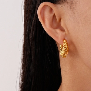 Elegantly textured gold croissant hoop earrings shown on a model for a chic metallic look