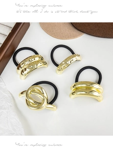 Close-up of four gold geometric hair ties with hammered and twisted metal textures