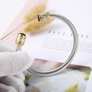 Two-tone cable twist bangle with black onyx stone inlay and gold-plated accents
