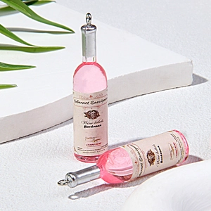 Close-up of pink miniature resin wine bottle pendants with silver caps and labels