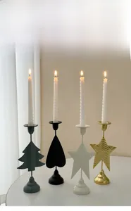 Close-up of heart and star shaped iron candle holders on a white tabletop