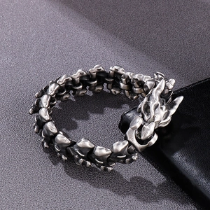 Dettaglio della chiusura a testa di drago e del bracciale maschile in acciaio vintage