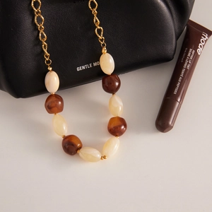 Collana retrò con perline in resina ambra e crema su una catena in oro raffinata