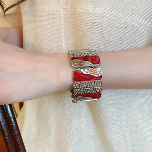 Detail of colorful enamel stretch bracelet with red wave patterns and silver texture