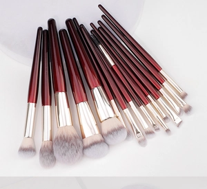 Detail of 15-piece professional makeup brush set with burgundy handles and gold ferrules