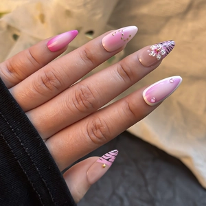 Détail de faux ongles imprimé zèbre rose avec fleurs 3D et pointes French élégantes