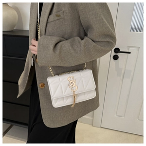 Quilted white leather crossbody bag with golden chain and tassel detail on model