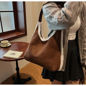 Brown faux suede tote bag with white faux fur trim shown in a cozy cafe setting