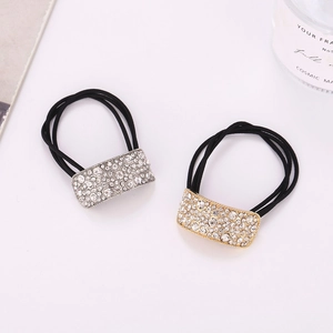 Detail of silver and gold curved rhinestone hair ties with elastic black bands