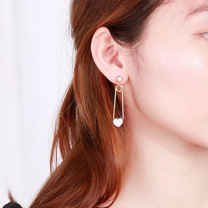 Boucles d'oreilles cœur doré avec strass portées par un mannequin en vue de profil