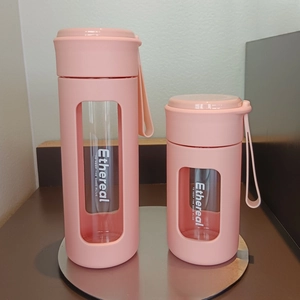 Close-up of pink silicone sleeve and carrying loop on heat-resistant glass water bottles