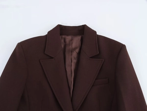 Details von kaffeebraunem Anzugjackenrevers und Wollstofftextur auf weißem Grund