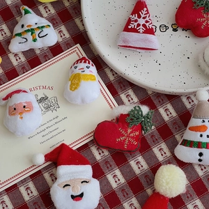 Close-up of plush Christmas ornaments featuring Santa and snowman for DIY bouquets