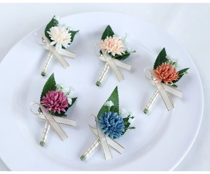 Detailed set of artificial wedding boutonnieres in five colors with elegant silk ribbons