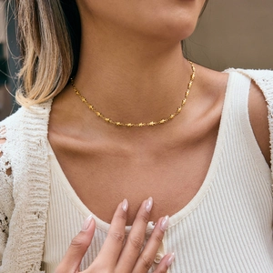 Gros plan d'un collier élégant plaqué or avec de petits pendentifs étoiles