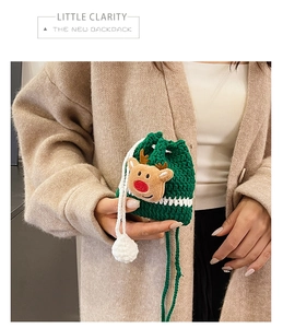 Detail of green handmade crochet reindeer bucket bag with red nose and drawstring tassels