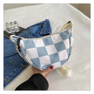 Detail of blue and white checkered chest bag with woven texture and zipper cord