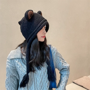 Detailaufnahme der schwarzen Strickmütze mit Bärenohren, Zöpfen und weichem Innenfutter