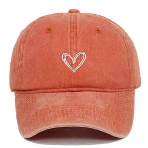 Detail of vintage washed orange cotton baseball cap with white heart embroidery
