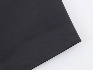 Vista macro dettagliata della trama del tessuto twill nero per questo completo da donna