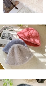 Detailansicht von weichen Kaninchenfell-Strickhüten in Pink, Blau und Beige von oben