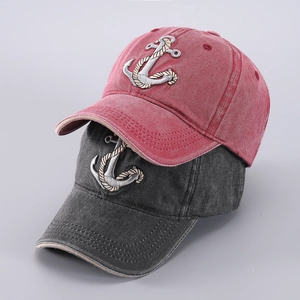 Close-up of anchor embroidery on washed denim baseball caps in red and charcoal grey