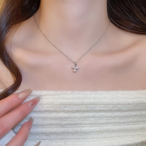 Close-up of stainless steel necklace with three white pearl pendants on model neck