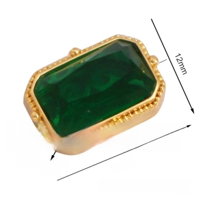 Macro detail of emerald green rectangular zircon bead with gold frame for DIY jewelry