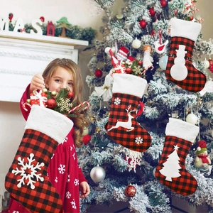Black and red plaid Christmas stockings with plush cuffs and festive holiday appliques for gifts.
