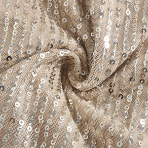 Macro view of champagne mesh fabric with silver sequins on a luxury backless top