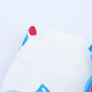 Detailed macro view of white midi skirt fabric with red polka dots and blue floral print
