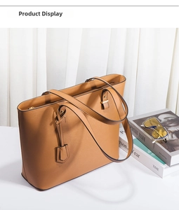 Detailed view of camel faux leather tote bag with cross-grain texture and gold hardware
