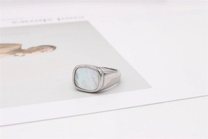 Détail de l'incrustation carrée en nacre sur la large bague minimaliste en acier argenté
