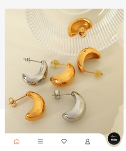 Close-up of crescent-shaped hollow earrings in polished gold and silver finishes