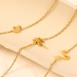 Polished 18k gold plated titanium steel bracelet with pineapple and palm leaf charms