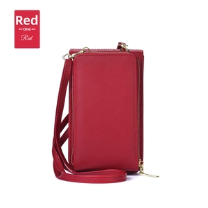 Macro shot of red leather textured crossbody bag with metal zipper and shoulder strap