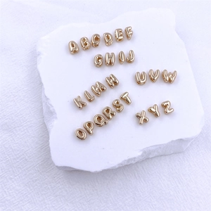 Polished KC gold bubble 26 alphabet letters DIY pendants set on white stone display