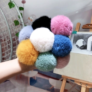 Detail of colorful plush faux fur pom-poms showing soft texture for hair accessories