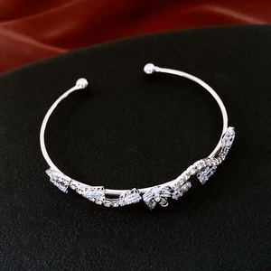 Macro shot of silver open cuff bracelet featuring light blue zircons and flower detail