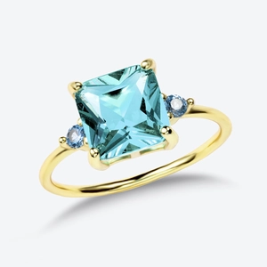 Macro shot of square light blue gemstone and round side stones on golden ring