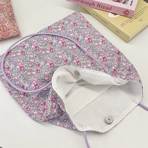 Floral tote bag showing inner zipper pocket and magnetic buckle closure with purple straps