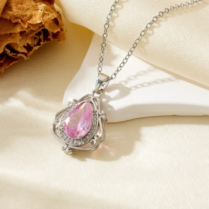 Close-up of pink pear-cut waterdrop pendant with white crystal halo on silver chain